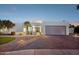 Charming single-story home featuring manicured landscaping and a brick driveway leading to a two-car garage at 16409 N 62Nd Way, Scottsdale, AZ 85254