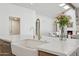 Modern kitchen island featuring a farmhouse sink, stainless fixtures, and a view of the living room at 16409 N 62Nd Way, Scottsdale, AZ 85254