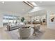 Bright living room featuring a vaulted ceiling, skylight, wood beams, and open floor plan to the kitchen at 16409 N 62Nd Way, Scottsdale, AZ 85254