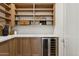 Well-organized pantry with custom cabinets, quartz counters, wine fridge, and ample storage space at 16409 N 62Nd Way, Scottsdale, AZ 85254