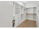 Spacious walk-in closet featuring hardwood floors, custom shelves and cabinets at 16409 N 62Nd Way, Scottsdale, AZ 85254