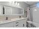 Bathroom with double sinks, a white vanity, decorative mirrors, and shower-tub combo at 16617 S 16Th Ave, Phoenix, AZ 85045