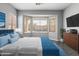 Bright bedroom features a bay window overlooking a pool and a modern dresser with a mounted TV at 16617 S 16Th Ave, Phoenix, AZ 85045