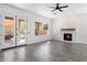 Bright living room features gray tile floors, doors to patio, and a fireplace with wooden mantle at 16617 S 16Th Ave, Phoenix, AZ 85045