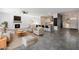 Spacious living room featuring a fireplace, ceiling fan, and an open floor plan leading into the kitchen at 16617 S 16Th Ave, Phoenix, AZ 85045