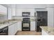 Bright kitchen features granite countertops, white cabinetry, and black appliances at 18823 N 41St Dr, Glendale, AZ 85308