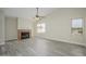 Bright, spacious living room with fireplace, light gray wood floors, and multiple windows at 18823 N 41St Dr, Glendale, AZ 85308