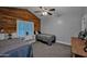 Cozy bedroom featuring a wood accent wall, ceiling fan, and two twin beds at 19450 E Silver Creek Ln, Queen Creek, AZ 85142