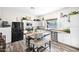 Bright kitchen featuring white cabinets, stainless steel appliances, a large island with seating, and wood-look flooring at 19450 E Silver Creek Ln, Queen Creek, AZ 85142