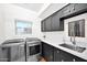 Well-equipped laundry room boasts modern appliances, stylish cabinetry and ample counter space for folding at 19450 E Silver Creek Ln, Queen Creek, AZ 85142