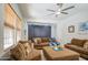 Bright living room featuring a comfortable couch, ceiling fan and light-filled space at 21186 E Sunset Dr, Queen Creek, AZ 85142