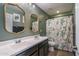 Bathroom featuring double sinks, decorative mirrors, and a cactus-llama shower curtain for a quirky vibe at 21512 S 225Th Way, Queen Creek, AZ 85142