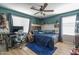 Comfortable bedroom with wood accents, blue color palette, fan, desk and decor at 21512 S 225Th Way, Queen Creek, AZ 85142