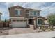 Charming two-story home with a well-manicured front yard, brick driveway, and attached two-car garage at 21512 S 225Th Way, Queen Creek, AZ 85142