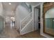 Bright hallway with wood-look tile floors, staircase, and doorway, creating an inviting entrance into the home at 21512 S 225Th Way, Queen Creek, AZ 85142