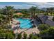 Aerial view of a community pool and lounge area surrounded by lush landscaping and residential homes for summertime fun at 21512 S 225Th Way, Queen Creek, AZ 85142