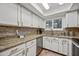 Close-up of the kitchen with granite countertops, stainless steel appliances, white cabinetry, and stylish backsplash at 2315 W Union Hills Dr # 119, Phoenix, AZ 85027