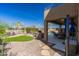 Beautiful backyard featuring a covered patio, outdoor kitchen, artificial turf, and lush landscaping at 2678 E Firestone Dr, Chandler, AZ 85249