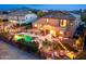 Aerial view of the backyard showing pool, patio, desert landscaping, and string lights at dusk at 2678 E Firestone Dr, Chandler, AZ 85249