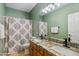 Bright bathroom features double sinks with granite countertops and a shower with patterned curtains at 2678 E Firestone Dr, Chandler, AZ 85249