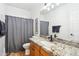 Well-lit bathroom featuring a granite countertop, vanity, and a shower-tub combination with a curtain at 2678 E Firestone Dr, Chandler, AZ 85249