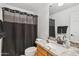 Bathroom featuring a single sink vanity with granite countertops, white cabinets, and a shower with dark curtains at 2678 E Firestone Dr, Chandler, AZ 85249