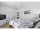 Bright bedroom with white walls, ceiling fan, and a bed with white and gray patterned bedding at 2678 E Firestone Dr, Chandler, AZ 85249