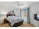 Light, bright bedroom with ceiling fan, a window with curtains, and a bed with grey and white patterned bedding at 2678 E Firestone Dr, Chandler, AZ 85249