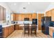 Bright kitchen with stainless steel appliances, wood cabinets, kitchen island with chairs, and wood flooring at 2678 E Firestone Dr, Chandler, AZ 85249