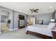 Spacious main bedroom with carpeting, ceiling fan, gray walls, TV, and an open door leading to main bathroom at 2678 E Firestone Dr, Chandler, AZ 85249