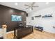 Office space with dark accent wall, ceiling fan, and laminate floors with a black desk and chair at 2678 E Firestone Dr, Chandler, AZ 85249