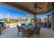 Covered patio dining area overlooking the pool, waterfall feature, and lush landscaping at 2678 E Firestone Dr, Chandler, AZ 85249