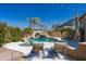 Backyard oasis with sparkling pool, rock waterfall, and lounge chairs, ideal for relaxing outdoors at 2678 E Firestone Dr, Chandler, AZ 85249