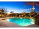 The beautiful pool area features a rock waterfall, lush greenery, and a cozy fireplace setting at 2678 E Firestone Dr, Chandler, AZ 85249