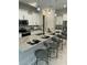 Bright kitchen with white cabinets, stainless steel appliances, and eat-in island with modern pendant lighting at 285 E Raleigh Dr, Chandler, AZ 85286