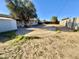 Large backyard featuring a covered patio, large concrete circle, storage shed, and mature trees at 3133 N 81St Ave, Phoenix, AZ 85033