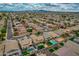 Expansive aerial view of a suburban neighborhood featuring well-manicured lawns, pools, and tree-lined streets under a cloudy sky at 3712 S 104Th Ln, Tolleson, AZ 85353