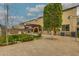 Landscaped backyard featuring a travertine patio, a custom outdoor kitchen with a grill, and mature landscaping at 3712 S 104Th Ln, Tolleson, AZ 85353