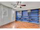 Bedroom with a blue wall-mounted bookshelf and hardwood flooring, offering ample storage and style at 3712 S 104Th Ln, Tolleson, AZ 85353