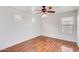 This bedroom has wood-look flooring, a ceiling fan with lights, and two windows providing natural light at 3712 S 104Th Ln, Tolleson, AZ 85353