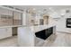 Bright kitchen showcasing a large island with a waterfall countertop and black cabinets for a modern design at 3712 S 104Th Ln, Tolleson, AZ 85353