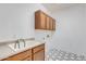 Bright laundry room including cabinetry, laundry sink, white walls, and tiled flooring at 3712 S 104Th Ln, Tolleson, AZ 85353