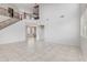 Bright living room with a soaring ceiling, open staircase, and neutral tile flooring throughout the main level at 3712 S 104Th Ln, Tolleson, AZ 85353