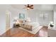 Well-lit bedroom featuring a ceiling fan, neutral decor, ensuite bathroom, and hardwood floors at 3712 S 104Th Ln, Tolleson, AZ 85353