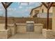 Outdoor kitchen featuring a built-in grill and sink under a wood pergola at 3712 S 104Th Ln, Tolleson, AZ 85353