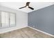 Neutral bedroom featuring tile floors, a ceiling fan, and plantation shutters for natural light at 406 W Fellars Dr, Phoenix, AZ 85023