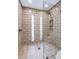 Modern shower with light brick-style tiling, glass doors, a built-in seat, and mosaic-tiled inset at 406 W Fellars Dr, Phoenix, AZ 85023