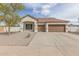 Beige single-story home featuring dual garage doors, a tiled roof, and complemented by desert landscaping at 4116 W Milada Dr, Laveen, AZ 85339