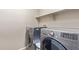 Modern laundry room with washer and dryer and floating shelves at 4116 W Milada Dr, Laveen, AZ 85339