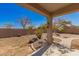 A covered patio overlooks a xeriscaped backyard with block wall, plants, and a winding brick paver walkway at 599 W Agrarian Hills Dr, San Tan Valley, AZ 85143